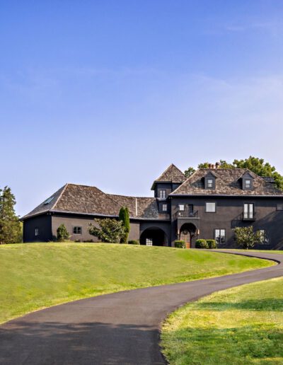 A large estate with a winding driveway on a sunny day.